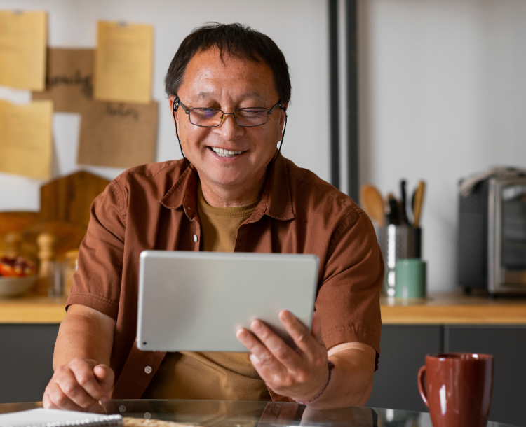 Elderly person smiling while video calling family on a tablet device