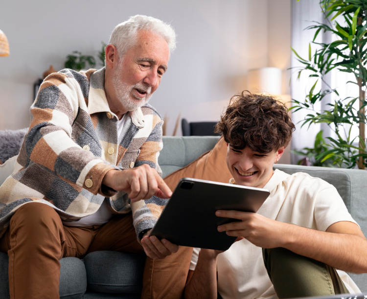 Senior learning to use a tablet with assistance from a younger family member